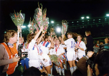 USA players celebrating with the Women's World Cup trophy.