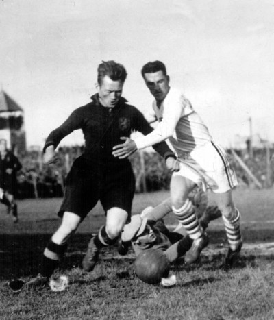 Belgium's Nicholas Hoydonck tries to clear the ball, challenged by USA's Bertram Patenaude.